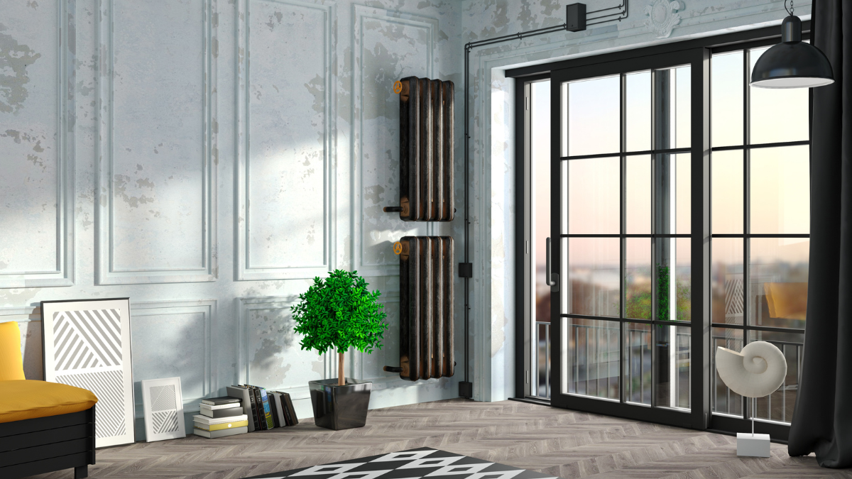 A modern living room with light-colored walls, a potted plant, tall radiators, large glass doors leading to a balcony, and contemporary decor including art frames and a spiral sculpture. Bramley Windows and Doors Installation and Replacement Service in Yorkshire, United Kingdom.